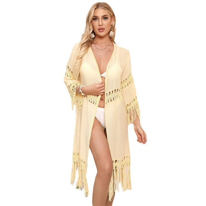 Yellow hand crocheted beach cover-up cardigan with tassel stitching on a mannequin