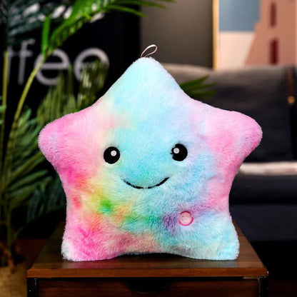 Colourful glowing five-pointed star plush pillow on a dark background.