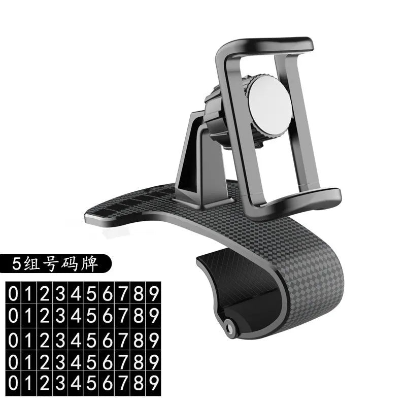 Black universal car phone holder with 360-degree rotating head on a car dashboard.