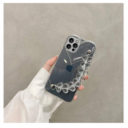 Transparent TPU iPhone case with love bracelet and heart chain design on a table.