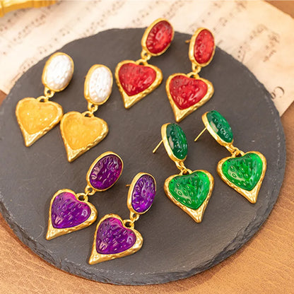 A pair of silver-tone stud earrings with a textured pleated oval love heart shape in various colour options.