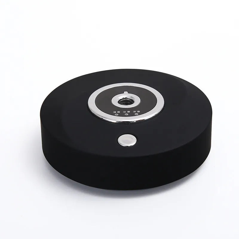Black plastic USB-powered vehicle mounted aromatherapy machine with anti-slip pad on a car dashboard.