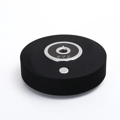 Black plastic USB-powered vehicle mounted aromatherapy machine with anti-slip pad on a car dashboard.