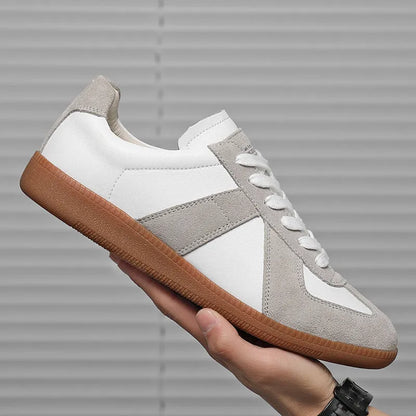 White Japanese-style retro low-top sneakers with round toe and flat rubber sole on a plain background.