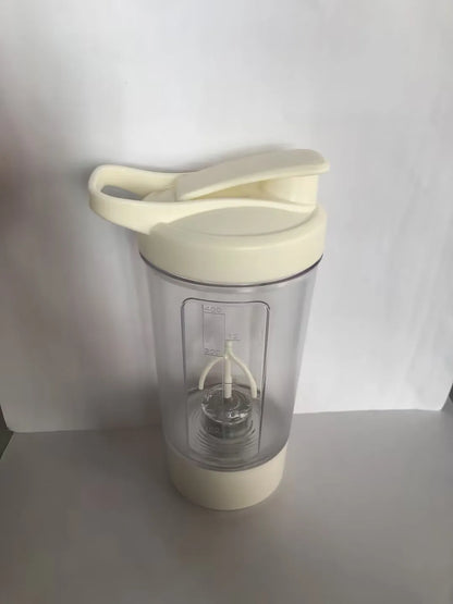 Black electric protein shaker bottle with lid and USB charging cable on a table