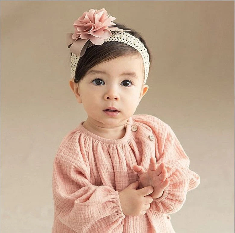 A charming flower headband for babies, featuring a delicate floral design and adjustable fit for a comfortable, stylish accessory.