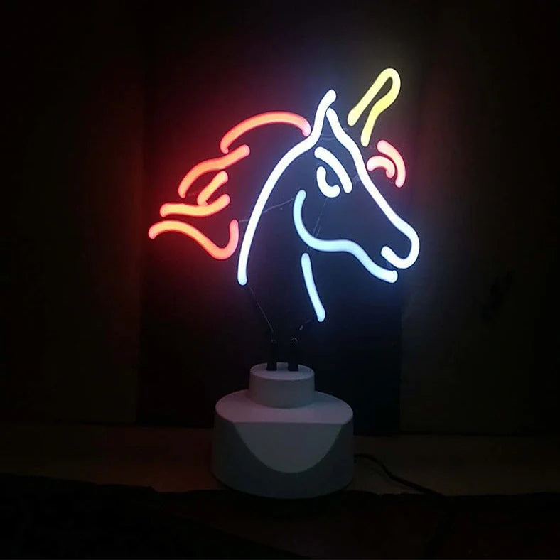 Unicorn-shaped neon light on desk with purple illumination, showing wall bracket option