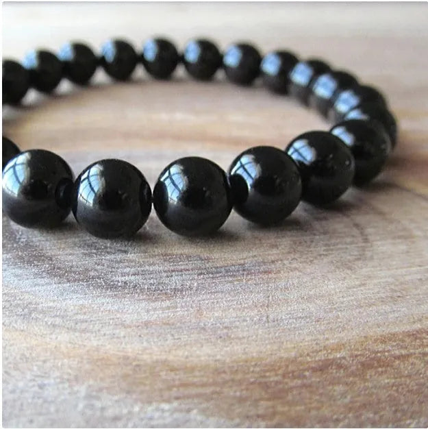 Geometric black agate bracelet for women with 8mm beads on a black elastic cord.