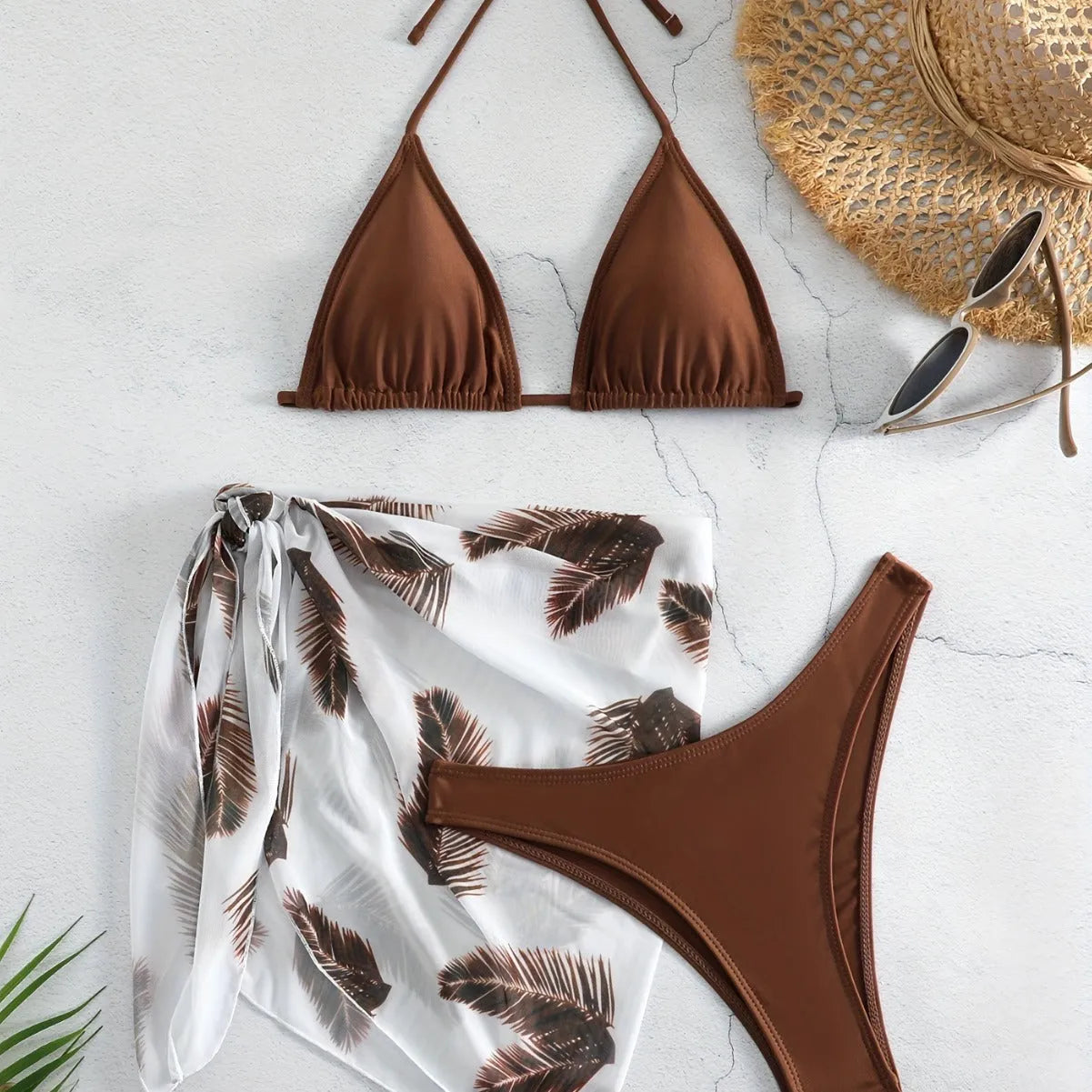 Women's orange three-piece bikini swimsuit with a matching printed gauze skirt laid flat.