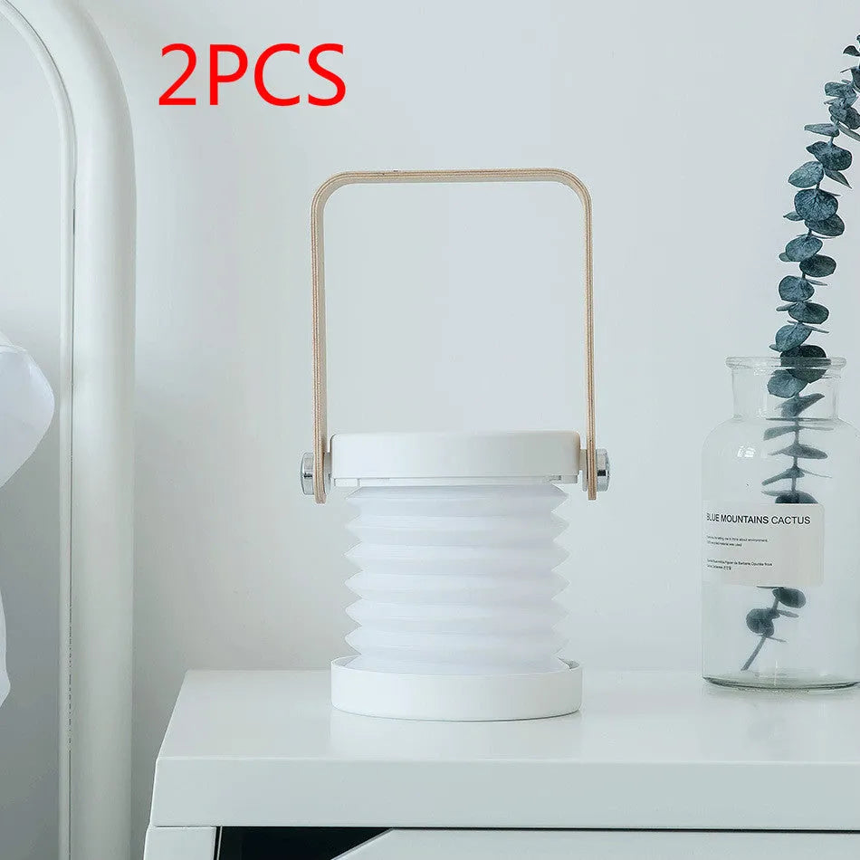White foldable USB rechargeable LED night light in both table lamp and tall lantern modes.