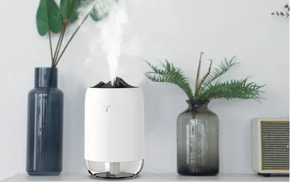 Compact cylindrical USB humidifier with night light in white, pink, or green, showing mist output.