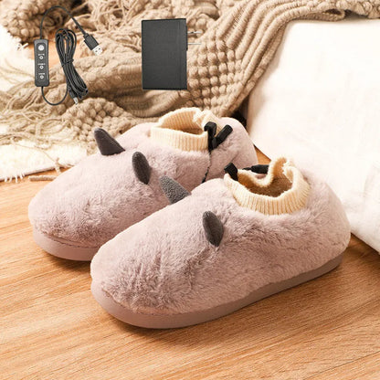 A pair of grey USB heated slippers with a connected cable, showing the soft velvet upper and plastic sole.