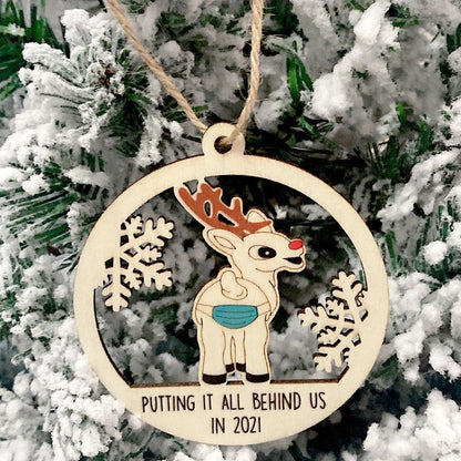 Wooden hollowed-out Christmas ornament with intricate snowman and deer laser-cut design