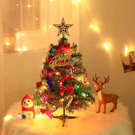 Mini Christmas tree with multi-color LED lights and festive accessories on a desktop