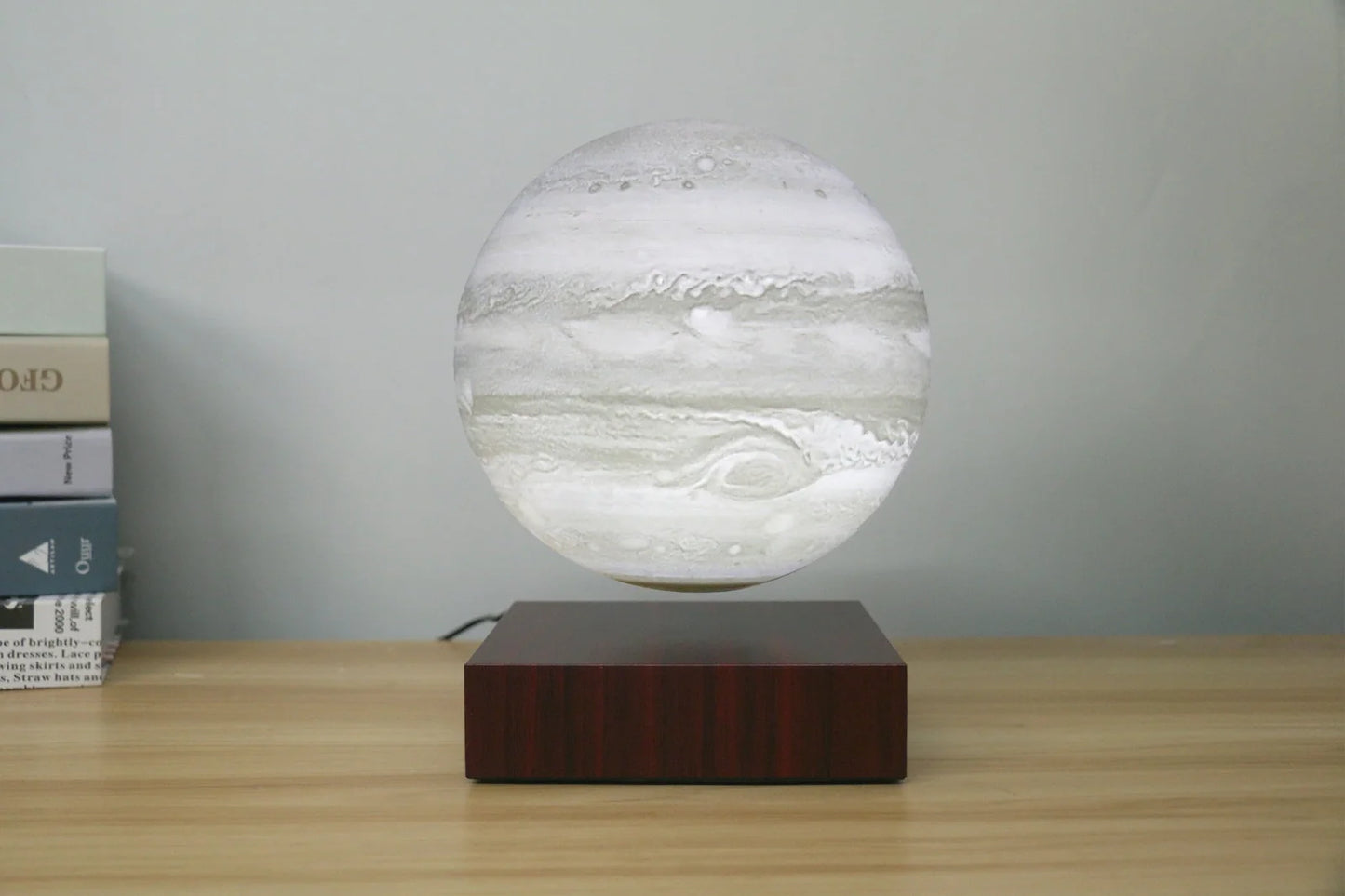 Levitating Earth or Jupiter lamp floating above base with LED illumination
