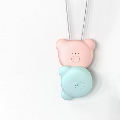 Pink wearable USB air purifier necklace on a table with USB cable, showing compact size.