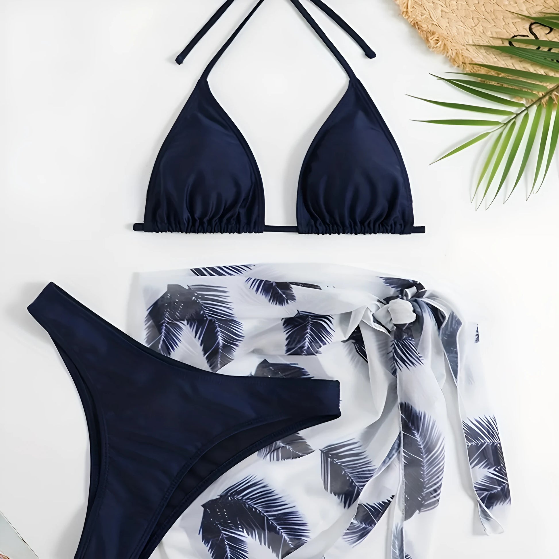 Women's orange three-piece bikini swimsuit with a matching printed gauze skirt laid flat.