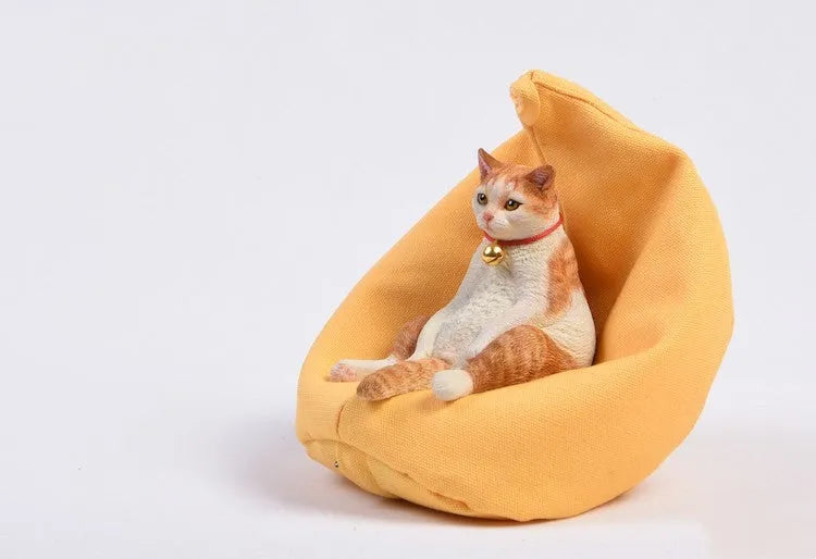 Lazy cat ornament on miniature sofa for car dashboard decoration, 7.5cm high with fabric art detailing