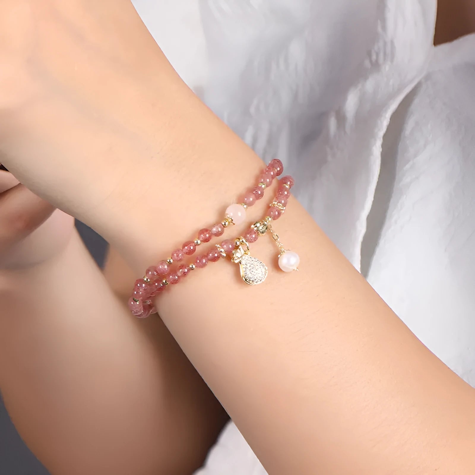 Women's geometric strawberry quartz crystal bracelet with a silver wallet money charm.