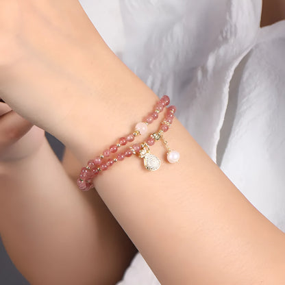 Women's geometric strawberry quartz crystal bracelet with a silver wallet money charm.