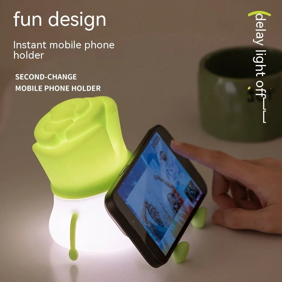 Green onion-shaped night light with warm white glow on desktop, showing 125mm width and flower design
