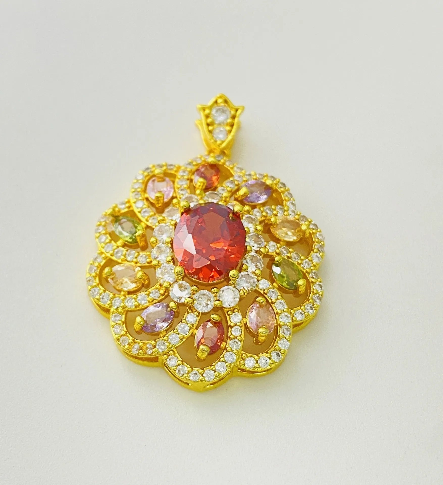 Close-up of a women's gold-coloured flower pendant necklace with a bright zircon stone centre.