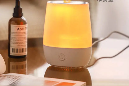 White USB aroma diffuser humidifier with simulated flame light effect on a table.