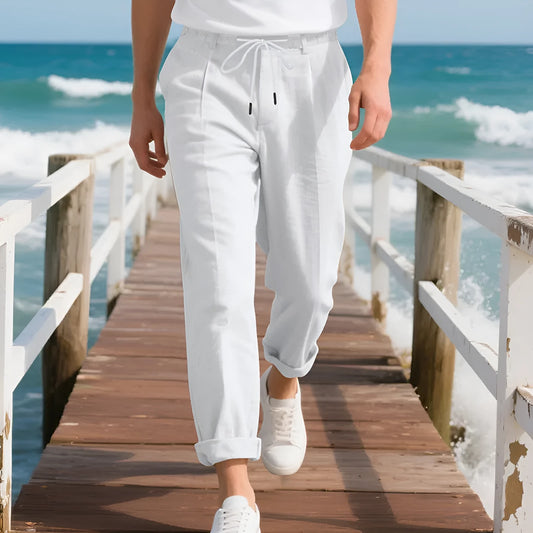 Men's light beige linen trousers with a loose straight leg and drawstring waist on a hanger.