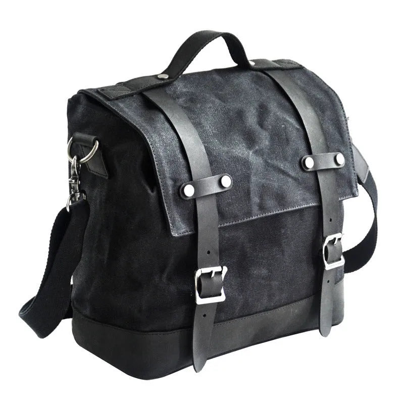 Black waterproof canvas motorcycle side bag with cowhide accents showing mounting straps