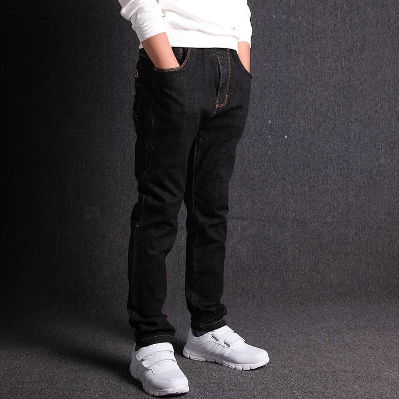 Boys' black micro-stretch cotton jeans showing 4-way flexibility and middle waist design