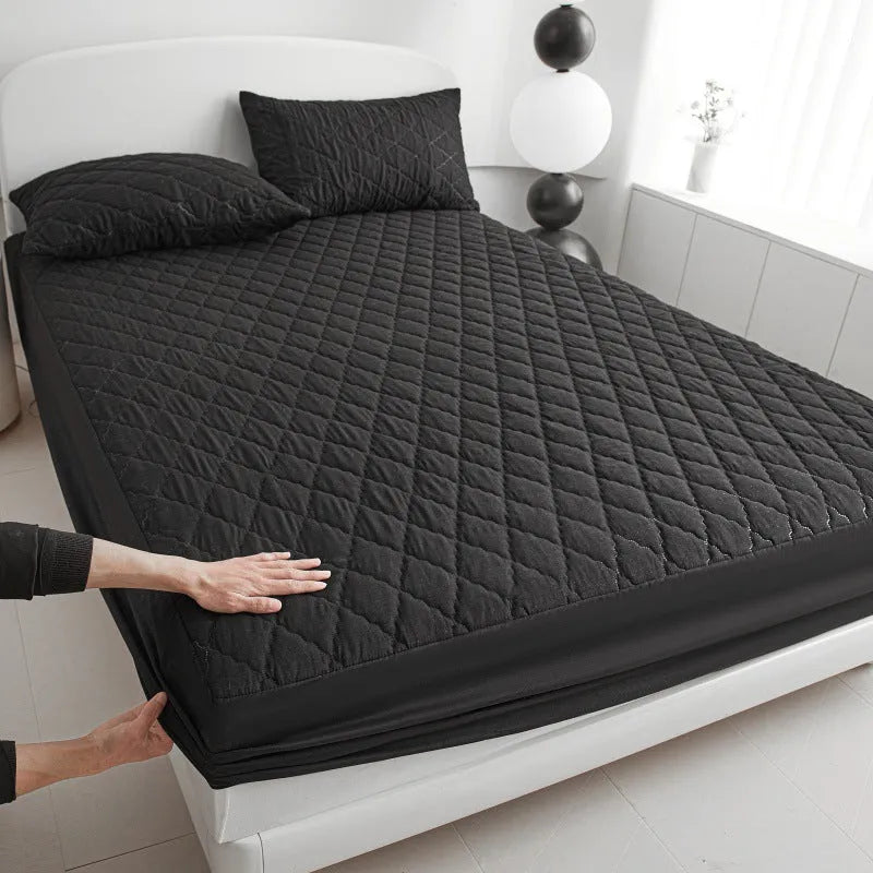 Diamond lattice quilted bamboo fibre mattress protector set in solid colour on a bed.