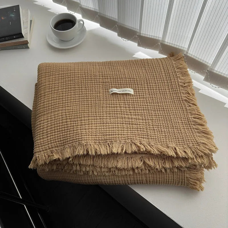 Four-layer gauze tassel blanket in cotton, showing tassel edges and textured fabric, available in multiple colours and sizes