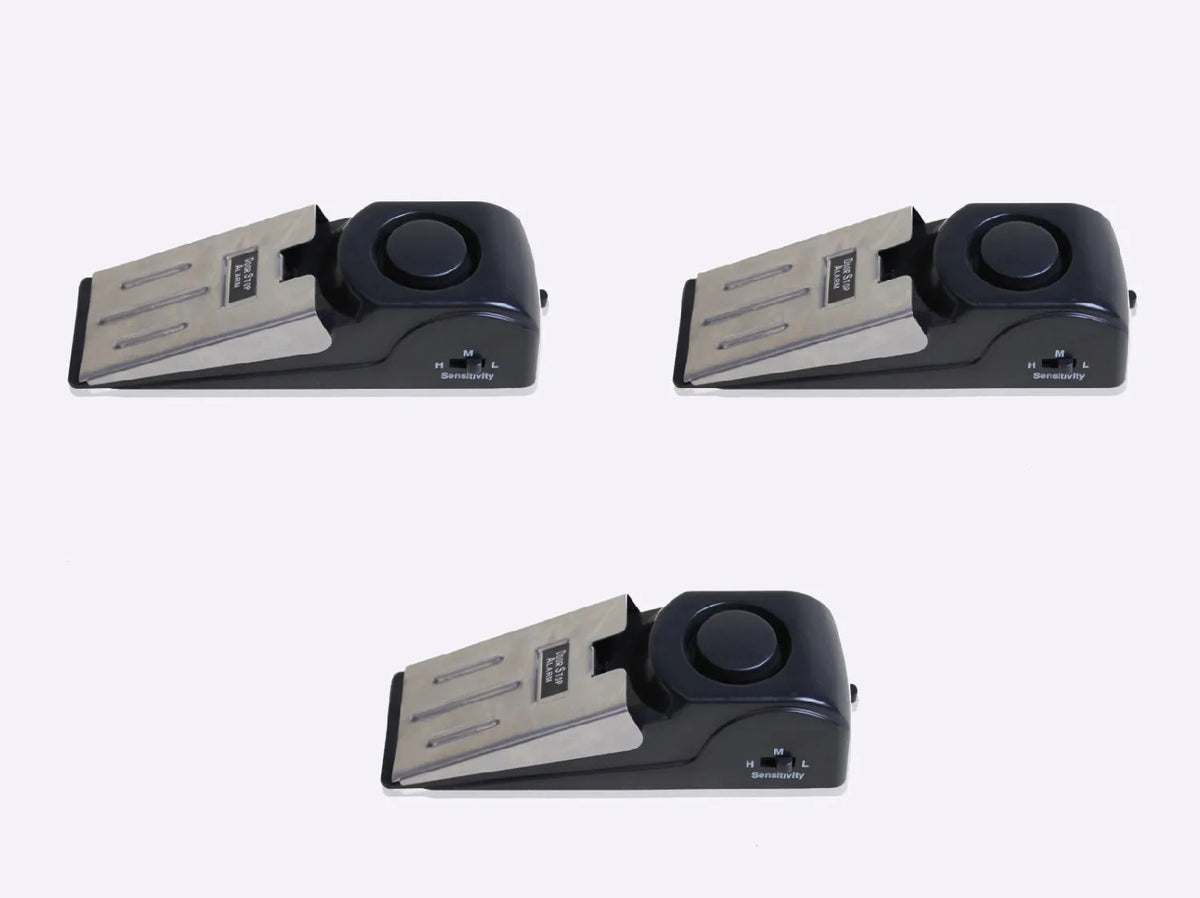 Portable wedge-shaped door stop alarm unit with stainless steel cover and sensitivity controls.