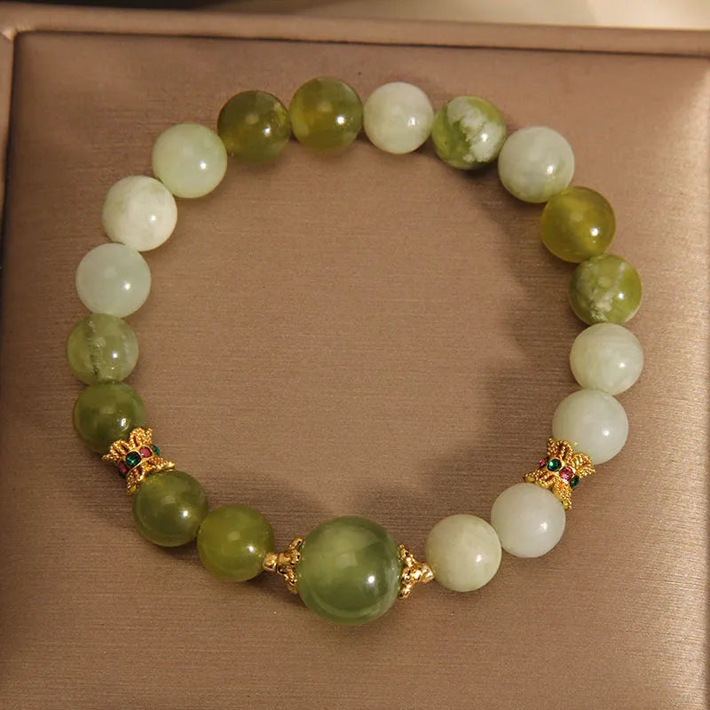 Original design women's bracelet with a green Xiuyan jade stone on wrist.