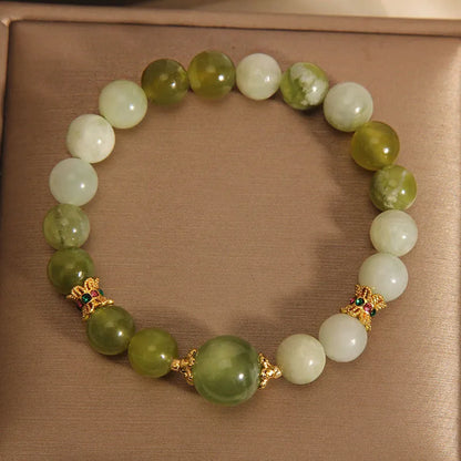 Original design women's bracelet with a green Xiuyan jade stone on wrist.