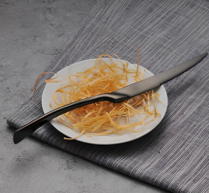 Four-piece black stainless steel cutlery set with mirror polishing showing fork, knife, coffee spoon, and soup spoon