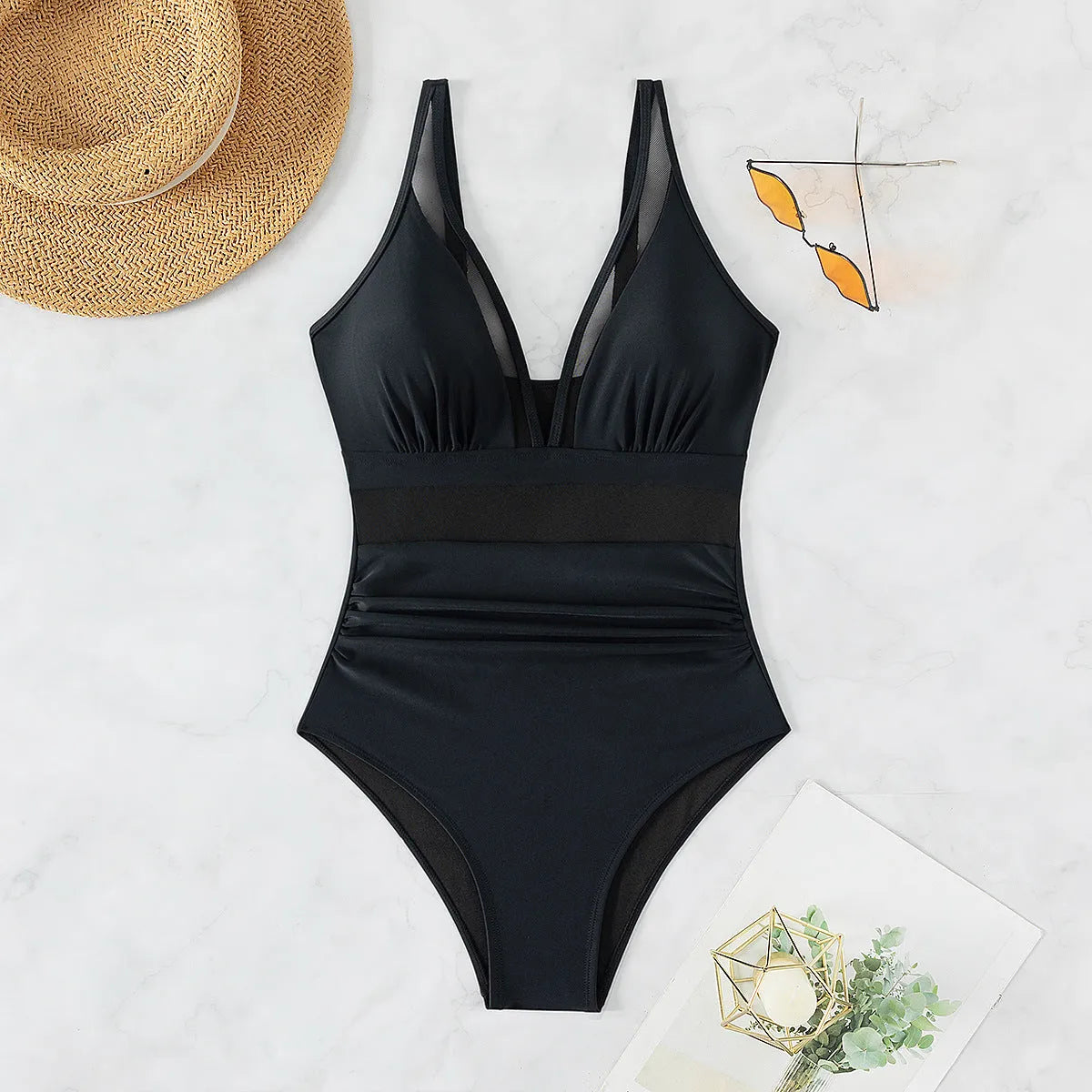 Black halter neck one-piece swimsuit with mesh panels, shown on a model.