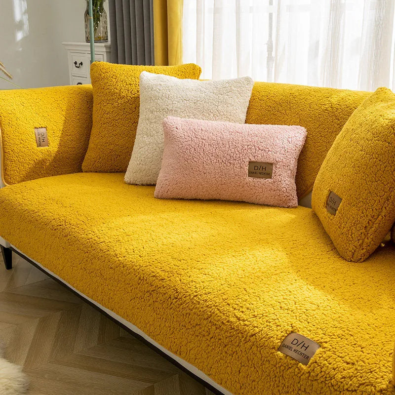 Beige lamb wool plush sofa cover with anti-slip backing on a grey fabric sofa.