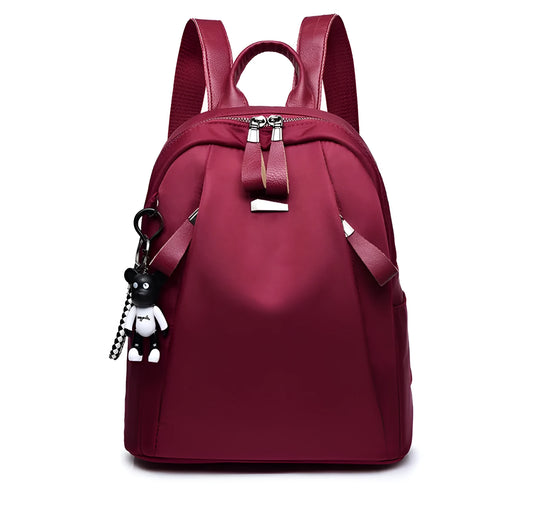 Medium square rucksack in Oxford cloth with two straps and a soft handle, shown in wine red.