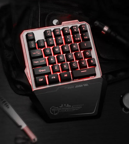 Black one-handed keyboard with RGB backlight and 1.8-metre USB cable on a desk