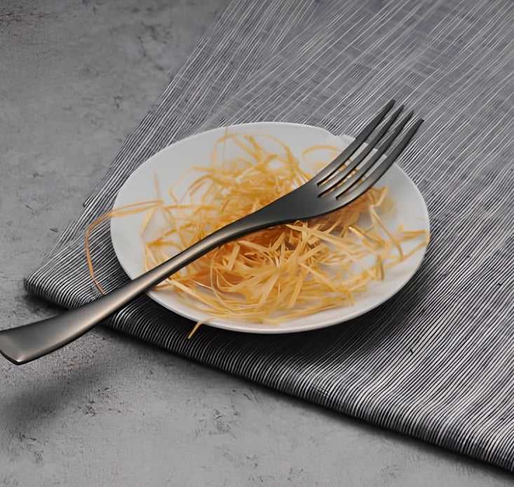 Four-piece black stainless steel cutlery set with mirror polishing showing fork, knife, coffee spoon, and soup spoon