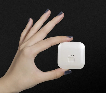 Pink wearable USB air purifier necklace on a table with USB cable, showing compact size.