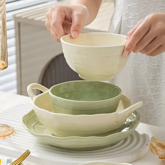Boxed set of seven solid-colour ceramic plates and bowls on a table.