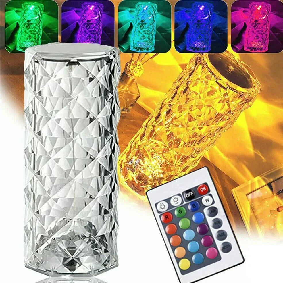 Clear acrylic LED table lamp with diamond-cut surfaces and remote control on wooden surface