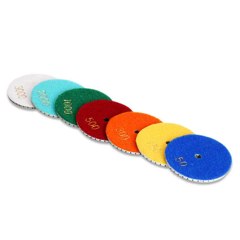 Set of 10 circular stone polishing pads with emery abrasive on a white background.