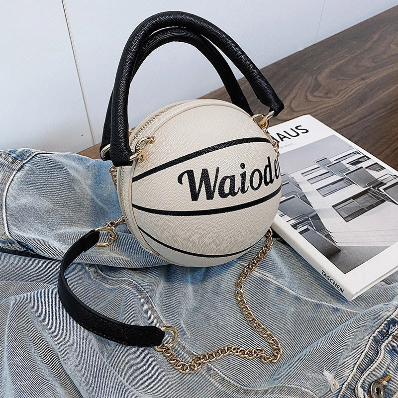 Basketball-shaped handbag with adjustable shoulder strap in pink, white, black, and brown