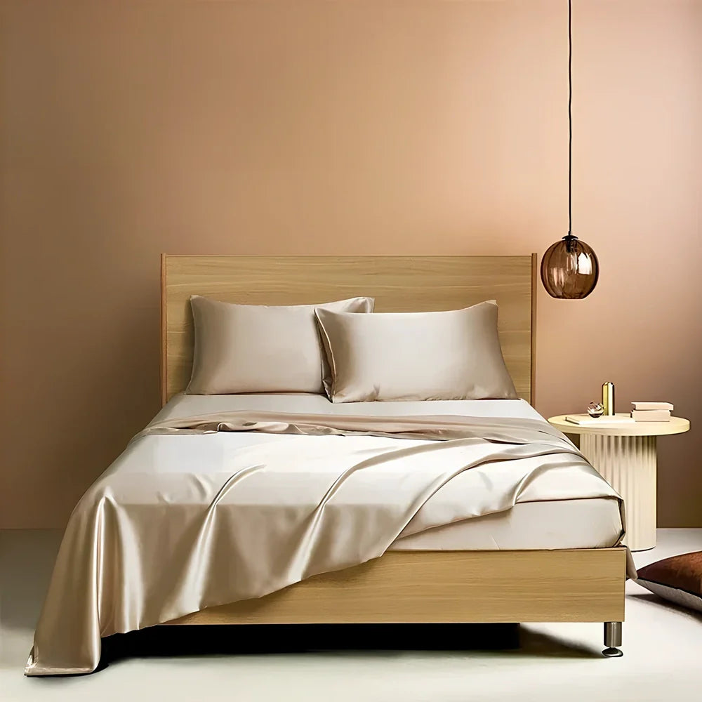 Navy blue floral pattern silk bedding set with quilt cover, fitted sheet, and two pillowcases on bed