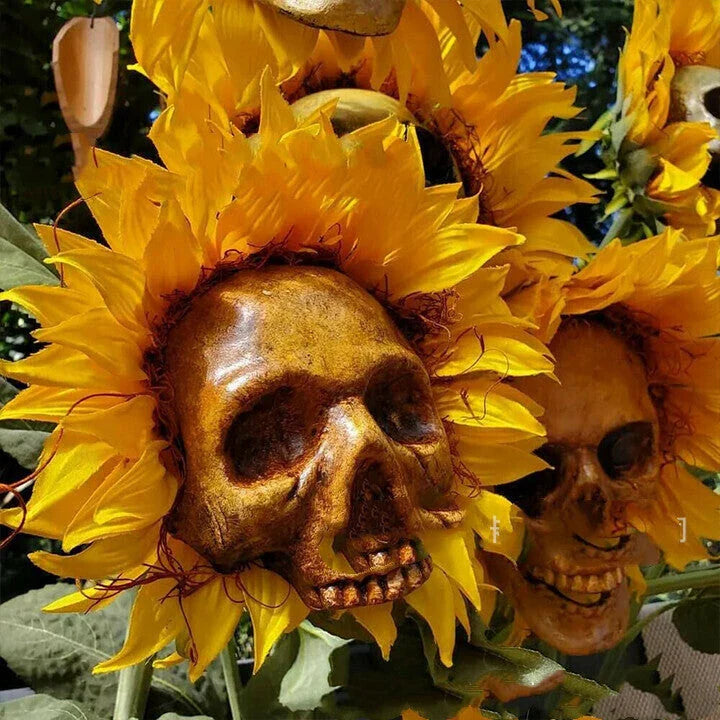 A group of skull-shaped sunflower ornaments arranged in a Halloween-themed outdoor display