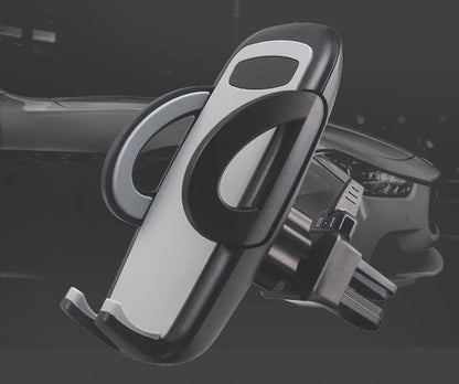 Black plastic mobile phone holder attached to a car air conditioning vent.