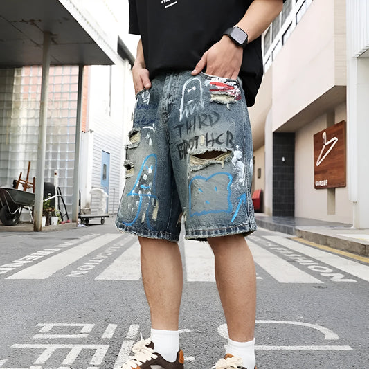Blue denim men's shorts with ripped knees and graffiti design, featuring a straight leg and zipper fly.